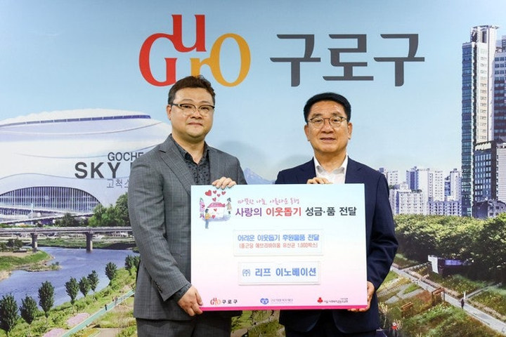 리프이노베이션 관계자가 이웃돕기 성금·성품 전달 판을 들고 기념 촬영하는 모습