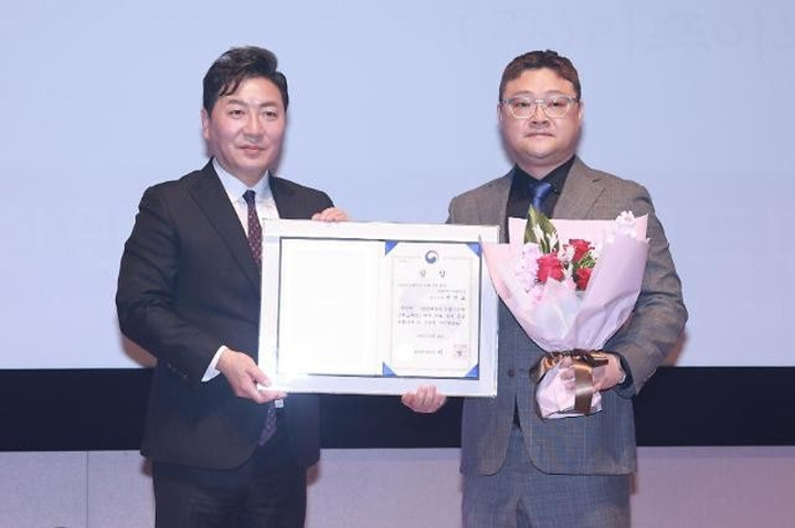 상장과 꽃다발을 든 수상 기념 사진